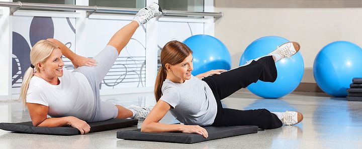Zwei Frauen machen Übungen für Bauch, Beine, Po